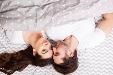 Mutlu çift yatakta eğlenmek. Birbirlerine zevk yatak odasında samimi şehvetli genç çift