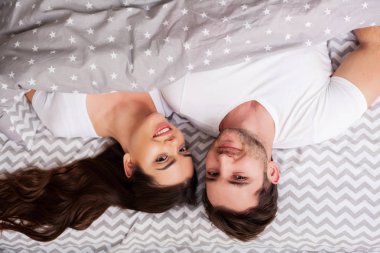 Mutlu çift yatakta eğlenmek. Birbirlerine zevk yatak odasında samimi şehvetli genç çift