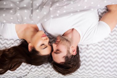 Mutlu çift yatakta eğlenmek. Birbirlerine zevk yatak odasında samimi şehvetli genç çift