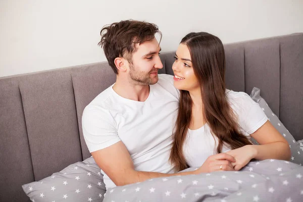 Glückliches Paar, das Spaß im Bett hat. intime sinnliche junge Paar im Schlafzimmer genießen einander — Stockfoto