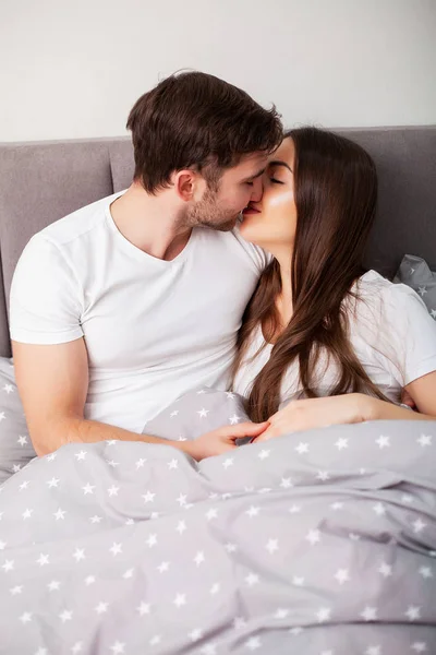 Glückliches Paar, das Spaß im Bett hat. intime sinnliche junge Paar im Schlafzimmer genießen einander — Stockfoto