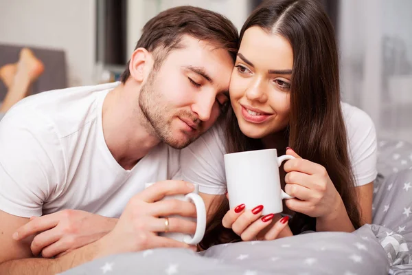 Glückliches Paar, das Spaß im Bett hat. intime sinnliche junge Paar im Schlafzimmer genießen einander — Stockfoto