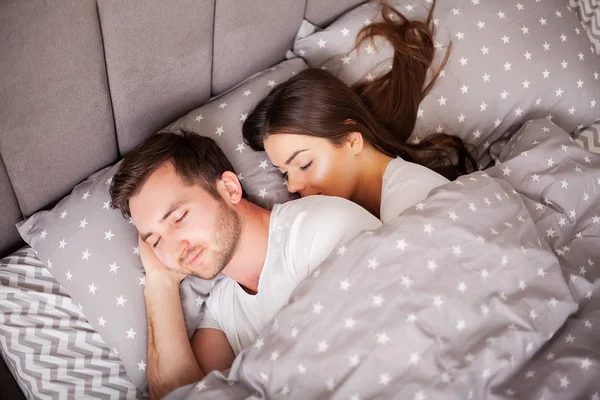 Pareja feliz divirtiéndose en la cama. Íntima sensual joven pareja en el dormitorio disfrutando el uno del otro — Foto de Stock