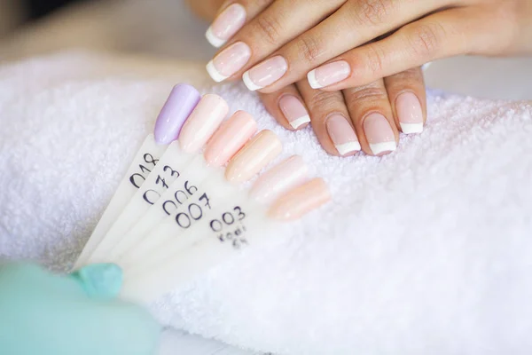 SPA manicure. French manicure at spa salon. Woman hands in a nail salon receiving a manicure procedure