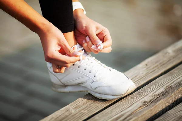 Fitness. Mujer corredora apretando encaje del zapato. Runner mujer pies corriendo en camino primer plano en zapato — Foto de Stock