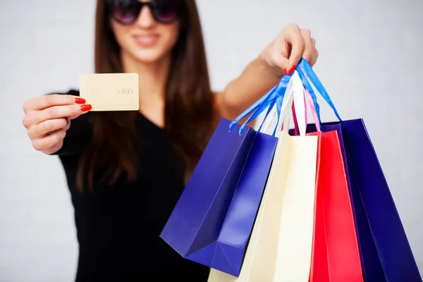 Compras. Fechar-se de mulher segurando saco de compras de papel de cor no fundo da parede branca — Fotografia de Stock