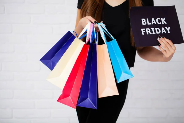 Compras. Primer plano de la mujer sosteniendo bolsa de compras de papel de color sobre fondo de pared blanco —  Fotos de Stock