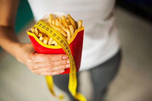 Dieta e alimentação saudável. Jovem mulher escolhendo entre frutas e junk food — Fotografia de Stock