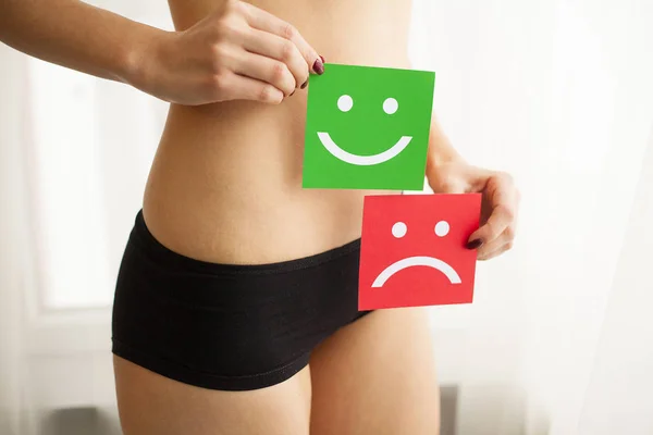 Woman Health Problem. Closeup Of Female With Fit Slim Body In Panties Holding Two Card With Sad Smiley And Happy Face Near Her Stomach. Digestive Disorders, Period Pain, Health Issues Concept