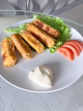 Kızarmış mozzarella peyniri beyaz tabakta ekmekli çubuklar