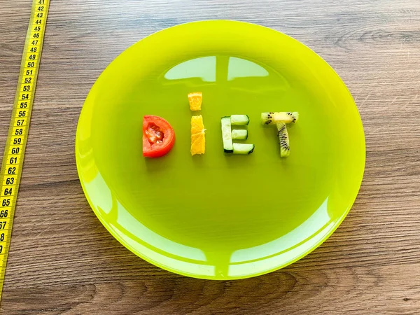 Slovo Dieta z nakrájené zeleniny v talíři s měřením na dřevěném pozadí — Stock fotografie
