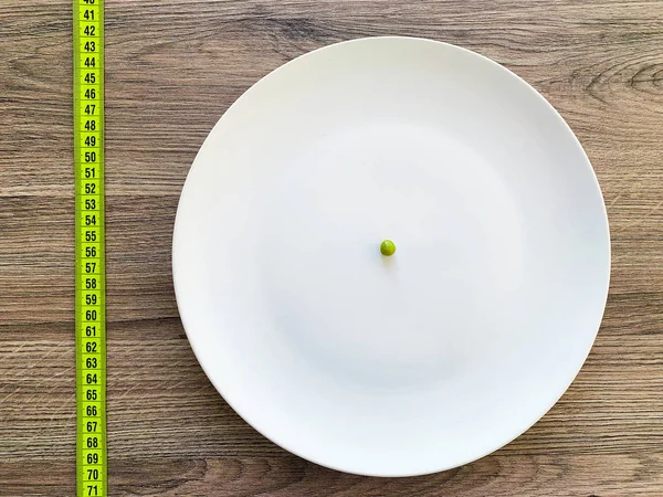 饮食。患有厌食症。在白色板上裁剪的图像豌豆 — 图库照片