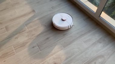Akıllı ev. Robot elektrikli süpürge daireyi belli bir zamanda otomatik olarak temizliyor.