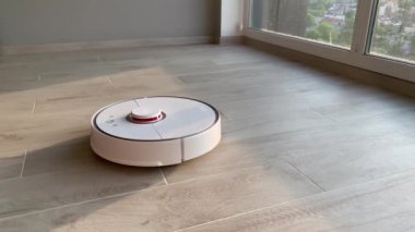Akıllı ev. Robot elektrikli süpürge daireyi belli bir zamanda otomatik olarak temizliyor.