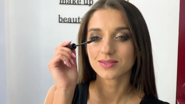 Maquillaje. Mujer en estudio de belleza hace maquillaje — Vídeos de Stock