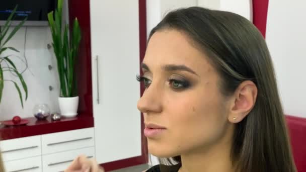 Maquillaje. Mujer en estudio de belleza hace maquillaje — Vídeos de Stock