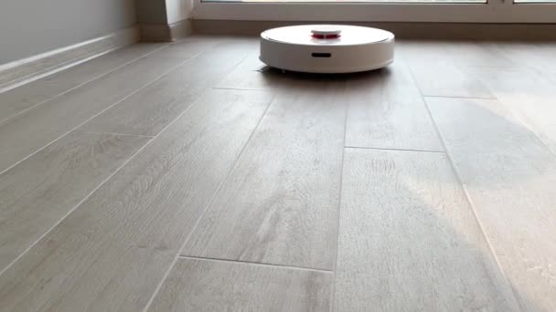 Hogar inteligente. Robot aspiradora realiza la limpieza automática del apartamento en un momento determinado — Vídeos de Stock