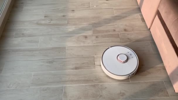 Hogar inteligente. Robot aspiradora realiza la limpieza automática del apartamento en un momento determinado — Vídeos de Stock