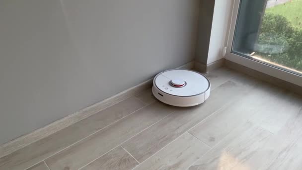 Akıllı ev. Robot elektrikli süpürge daireyi belli bir zamanda otomatik olarak temizliyor. — Stok video