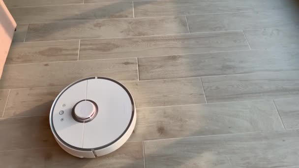 Έξυπνο σπίτι. Ρομπότ ηλεκτρική σκούπα εκτελεί αυτόματο καθαρισμό του διαμερίσματος σε ένα ορισμένο χρονικό διάστημα — Αρχείο Βίντεο