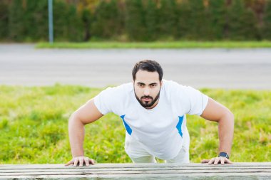 Yeşil parkta şınav yapıyor spor giyim Portre sportif adam 30s