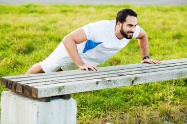 Yeşil parkta şınav yapıyor spor giyim Portre sportif adam 30s