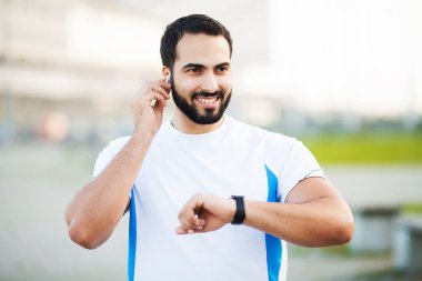 Dinleme müzik için kulaklık kullanarak spor adam parkta koşmak sabahı