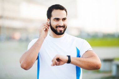 Dinleme müzik için kulaklık kullanarak spor adam parkta koşmak sabahı