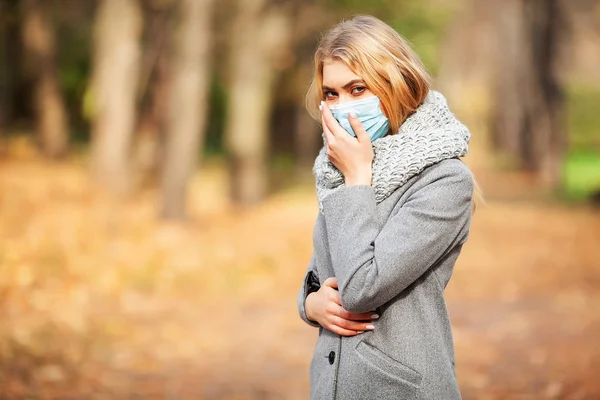Resfriado y gripe. Mujer con mascarilla médica al aire libre — Foto de Stock