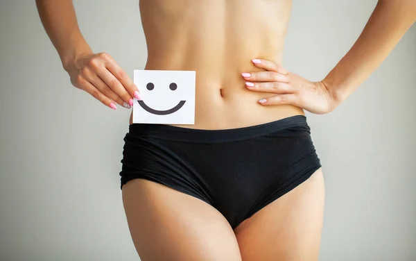 Women Health. Closeup Of Healthy Female With Beautiful Fit Slim Body In White Panties Holding White Card With Happy Smiley Face In Hands. Stomach Health And Good Digestion Concepts