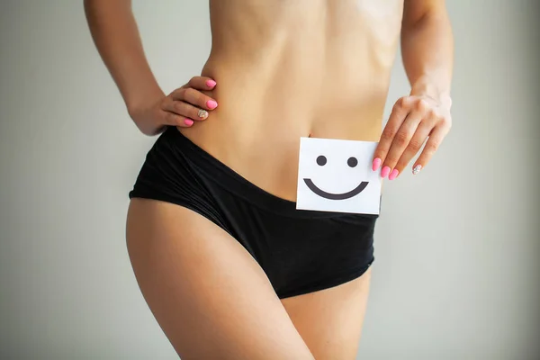 妇女健康。健康女性与美丽的适合苗条的身体在白色内裤拿着白卡与快乐笑脸在手的特写。胃健康和良好的消化概念 — 图库照片