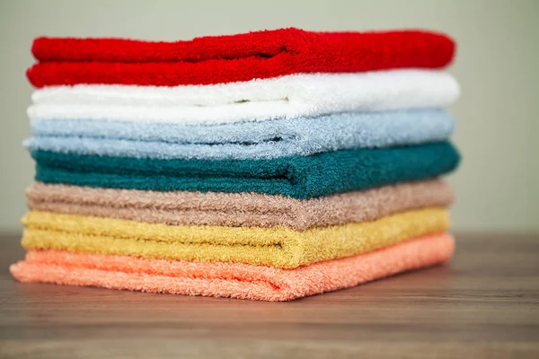 将五颜六色的毛巾堆放在桌子上的浴室 — 图库照片