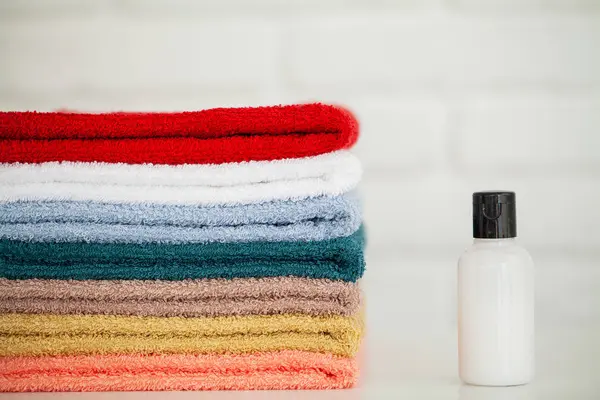 Productos cosméticos y toallas de algodón sobre mesa de madera blanca en salón de belleza — Foto de Stock