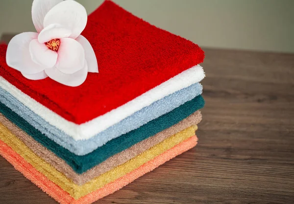Pila de toallas de colores en el baño en la mesa — Foto de Stock