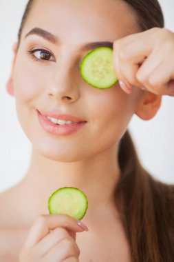 Skincare. Gözleri salatalık ile güzel genç kadın