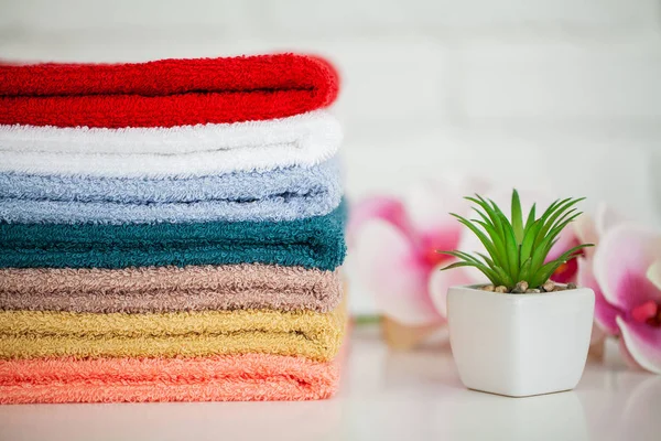 Toallas de baño esponjosas sobre mesa de madera clara con decoración y fondo blanco — Foto de Stock