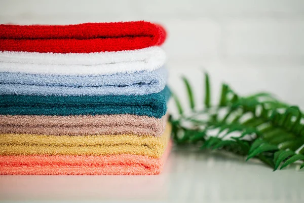 Toallas de algodón coloridas en el baño sobre mesa de madera blanca — Foto de Stock