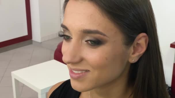 Красивая женщина делает профессиональный макияж в студии красоты — стоковое видео