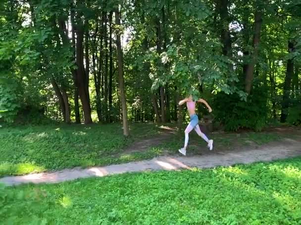 Ο υγιής τρόπος ζωής. Γυναίκα που κάνει τζόκινγκ στα μονοπάτια του δάσους. Αργή κίνηση. — Αρχείο Βίντεο