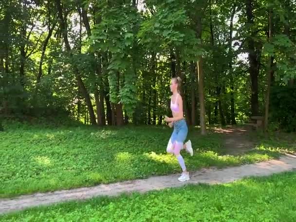 आरोग्यदायी जीवनशैली महिला जंगलाच्या मार्गावर धावत आहे. हळू चळवळ . — स्टॉक व्हिडिओ