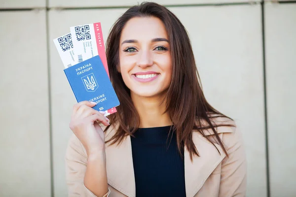 Путешествие. Женщина с двумя билетами в заграничном паспорте рядом с аэропортом — стоковое фото