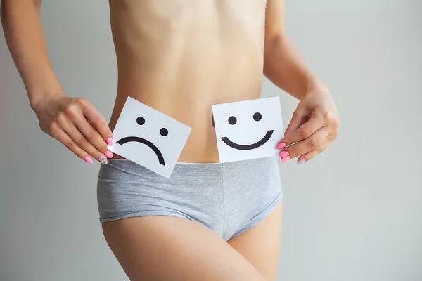 Salud de la mujer. Cuerpo femenino sosteniendo triste tarjeta sonriente cerca del estómago . — Foto de Stock
