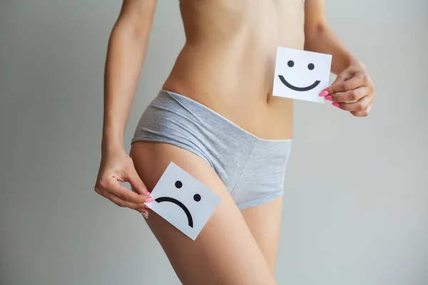 Salud de la mujer. Cuerpo femenino sosteniendo triste tarjeta sonriente cerca del estómago . — Foto de Stock
