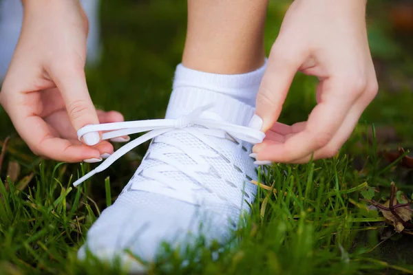 Woman Runner Tightening Shoe Lace. Runner Woman Feet Running On Road Closeup On Shoe Royalty Free Stock Photos