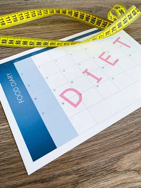 Diet plan concept. Measuring tape and diet plan on wooden background. — Stock Photo, Image