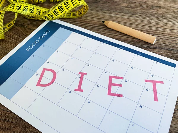 Diet plan concept. Measuring tape and diet plan on wooden background. — Stock Photo, Image