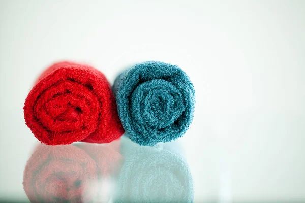 Colored towels on white table with copy space on bath room background. — Stock Photo, Image