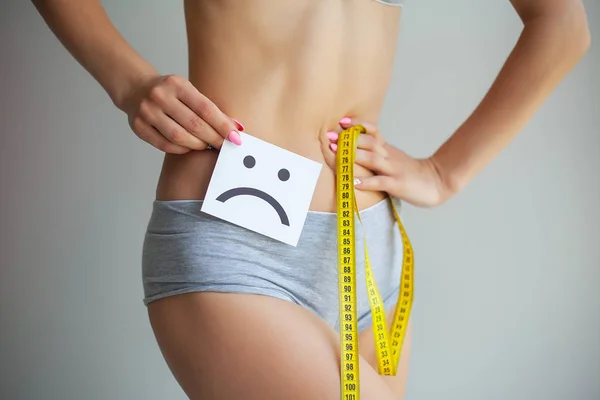 Concepto de dieta. Manos midiendo la cintura con una cinta. Mujer delgada y saludable en su casa — Foto de Stock