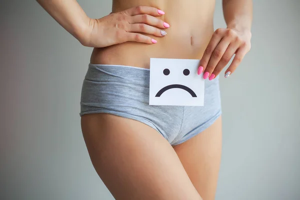 Zdraví ženy. Ženské tělo drží smutný smajlík kartu v blízkosti žaludku — Stock fotografie