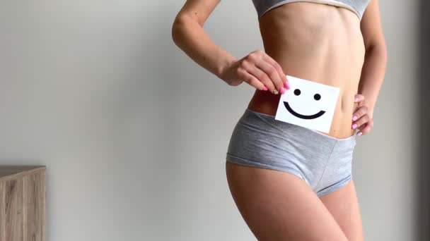 Salud de las mujeres. primer plano de la hembra sana con hermoso ajuste delgado cuerpo en bragas blancas sosteniendo tarjeta blanca con la cara sonriente feliz en las manos. Salud estomacal y buenos conceptos de digestión. Alta resolución — Vídeos de Stock